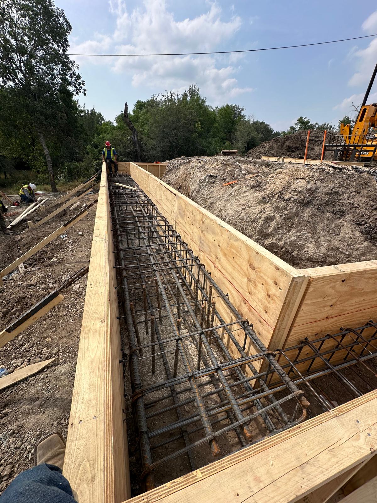 Long reinforced concrete bridge form prepared for placement
