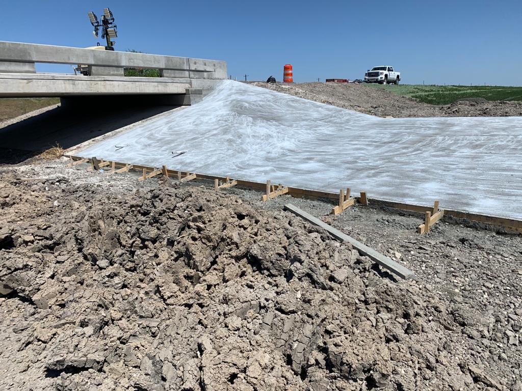 Finished concrete slope protection beside a bridge